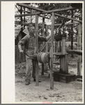 Cut-over farmer near Amite, Louisiana, drawing water from well