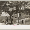 Painting grave marker in cemetery, All Saints' Day in New Roads, Louisiana