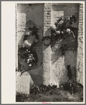 Decorations on side of family burial vault in cemetery at New Roads, Louisiana on All Saints' Day