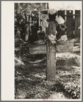 Decorated headstone in cemetery, New Roads, Louisiana on All Saints' Day. Artificial flowers are made of paper