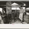 Owner atop his turpentine still. Goosneck runs from the still to the condenser coils where vapors are chilled. State Line, Mississippi