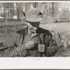 Farmer of Chicot Farms, Arkansas striking match on button of overalls