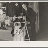 Salesman standing in front of store on Saturday afternoon, Laurel, Mississippi