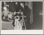 Salesman standing in front of store on Saturday afternoon, Laurel, Mississippi