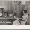 House wife reading in living room, Chicot Farms, Arkansas