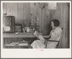 House wife reading in living room, Chicot Farms, Arkansas