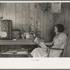 House wife reading in living room, Chicot Farms, Arkansas