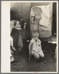 Child of white migrant worker in front of trailer home, Weslaco, Texas