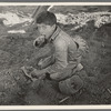 Young Mexican boy, carrot worker, eating "second breakfast" in field near Santa Maria, Texas. The lunches of the Mexican workers usually consist of tortillas and fried onions and cold coffee