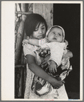 Mexican girl with baby sister in front of hut near Santa Maria, Texas