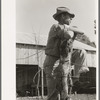 Farmer leaning on fence near Weslaco, Texas. FSA (Farm Security Administration) client