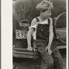 Child of white migrant worker sitting on bumper of their car from Arizona, near Harlingen, Texas