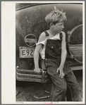 Child of white migrant worker sitting on bumper of their car from Arizona, near Harlingen, Texas