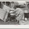 Unloading household goods from trailer in process of setting up camp near Harlingen, Texas