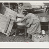 Unloading household goods from trailer in process of setting up camp near Harlingen, Texas