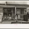 Mexican sitting on porch of store, Alamo, Texas