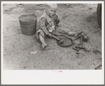 Child of white migrant worker playing with automobile tools near Harlingen, Texas