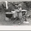 Child of white migrant worker ironing in camp near Harlingen, Texas