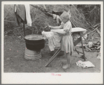 Child of white migrant worker ironing in camp near Harlingen, Texas