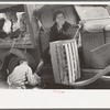 Wife of fruit vendor having shoes shined at market in San Antonio, Texas