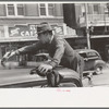 Man painting automobile top near market, San Antonio, Texas