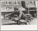 Man painting automobile top near market, San Antonio, Texas