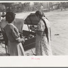 Mexican women buying pottery from street peddler, San Antonio