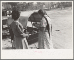 Mexican women buying pottery from street peddler, San Antonio