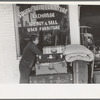 Woman in front of secondhand furniture store, San Antonio, Texas