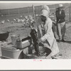 Woman washing her clothes on her farm at El Indio, Texas