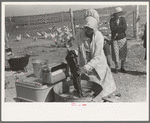 Woman washing her clothes on her farm at El Indio, Texas