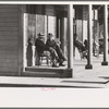 Men sitting in front of hotel in the early morning, Little Fork [i.e. Littlefork], Minnesota