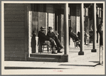 Men sitting in front of hotel in the early morning, Little Fork [i.e. Littlefork], Minnesota