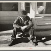 Arnegard, McKenzie County, North Dakota. Old man sitting on a store step