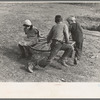 Farm children playing on homemade merry-go-round. Williams County, North Dakota