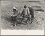 Farm children playing on homemade merry-go-round. Williams County, North Dakota