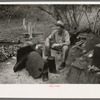 White migrant worker sitting in front of fire. He lived with two other white men migrant workers. He was a Texan. Harlingen, Texas