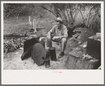 White migrant worker sitting in front of fire. He lived with two other white men migrant workers. He was a Texan. Harlingen, Texas