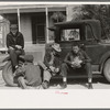 Men sitting on car, street of Raymondville, Texas