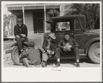 Men sitting on car, street of Raymondville, Texas