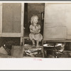 Migrant child sitting in doorway of trailer, Edinburg, Texas