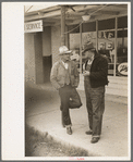 Men talking on sidewalks of Sinton, Texas