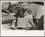 Wife of migrant auto wrecker sewing seat cushion of wrecked auto, Corpus Christi, Texas