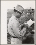 Mexican laborer contractors employ a checker who keeps track of number of baskets cut by each cutter, La Pryor, Texas. He also okays the baskets for shipping from fields