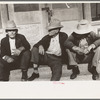 Residents of Crystal City, Texas sitting on steps of store