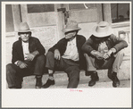 Residents of Crystal City, Texas sitting on steps of store