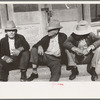 Residents of Crystal City, Texas sitting on steps of store