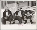 Residents of Crystal City, Texas sitting on steps of store