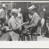 Salesman displaying sample of suit material to farmer, Hammond, Louisiana