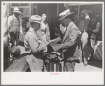 Salesman displaying sample of suit material to farmer, Hammond, Louisiana